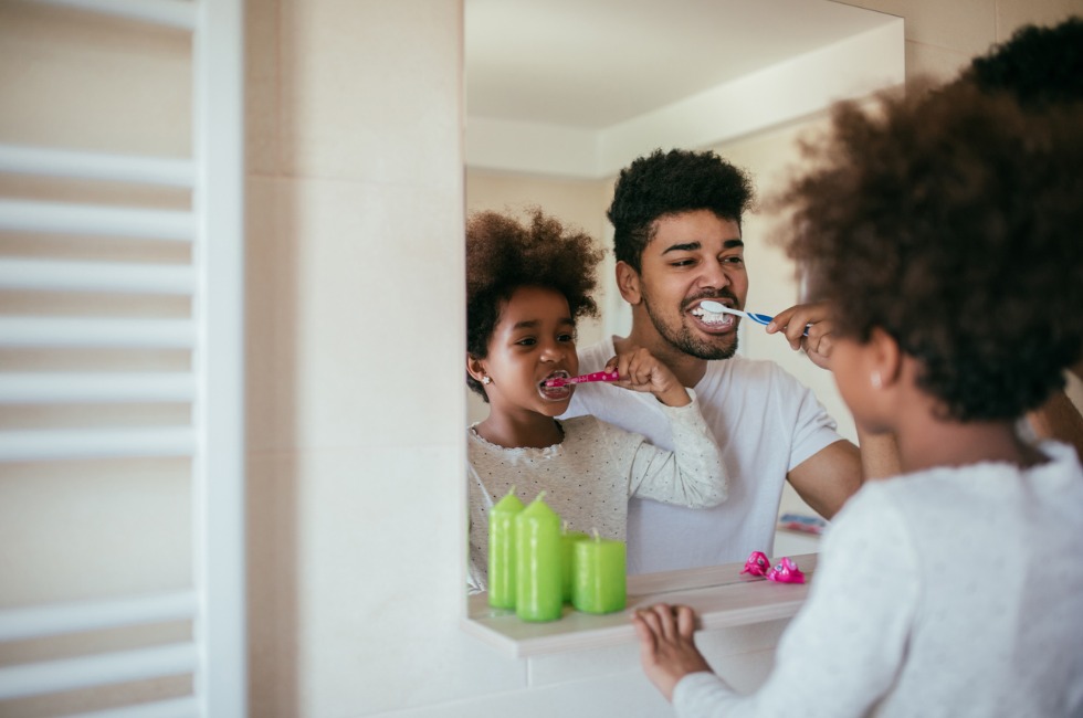 Dad brushing teeth with daughter